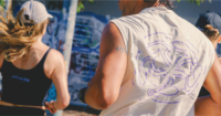 A man and woman running. The man has a screen printed shirt.
